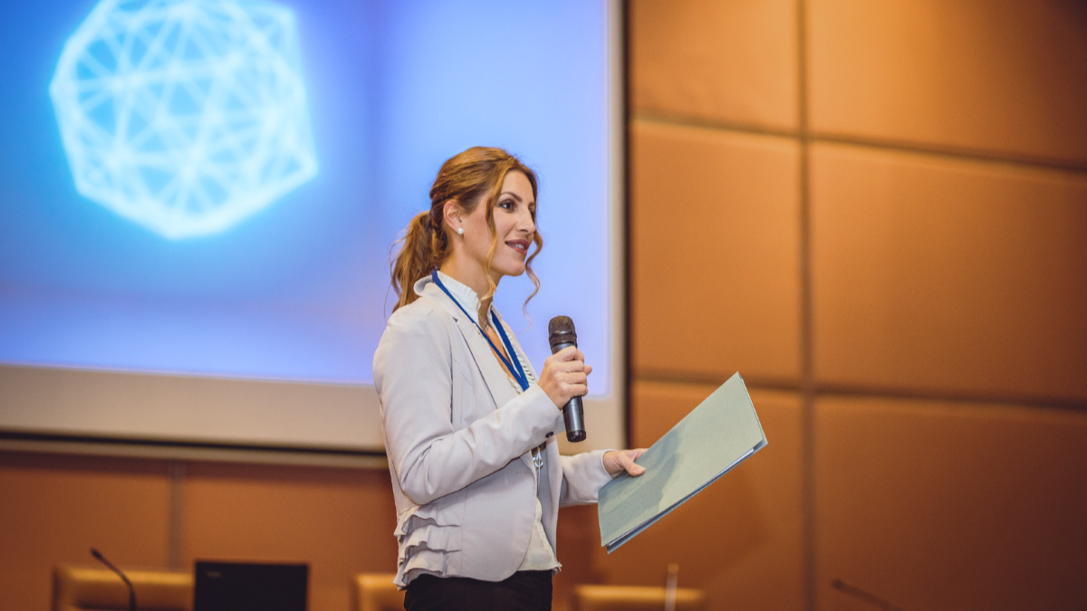 Speaker at stage holding microphone.