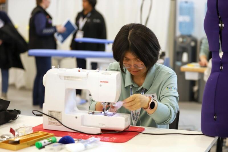 Competitor sewing at a sewing machine during an Abilympics competition.