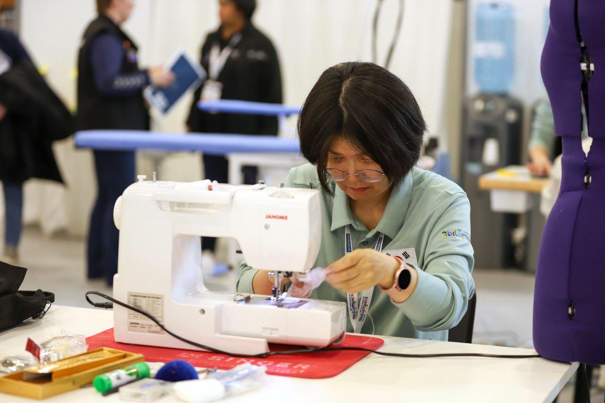 Competitor sewing at a sewing machine during an Abilympics competition.
